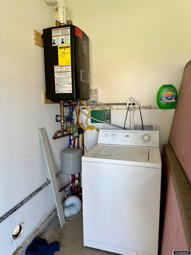 washroom with water heater and washer / dryer