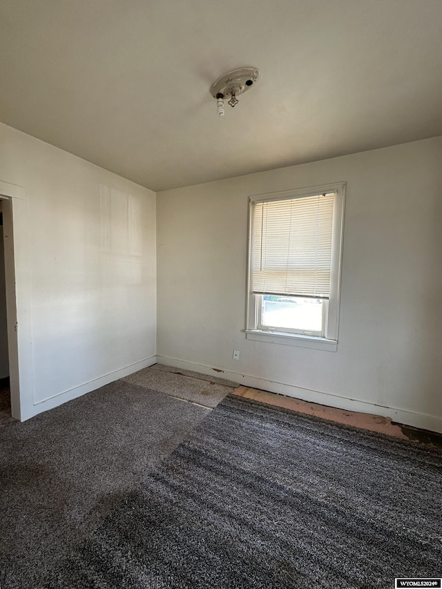 spare room with dark carpet