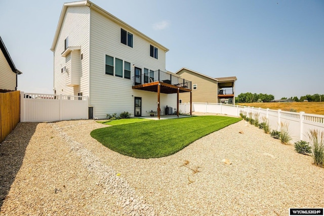 rear view of house with a patio, a lawn, and a fenced backyard