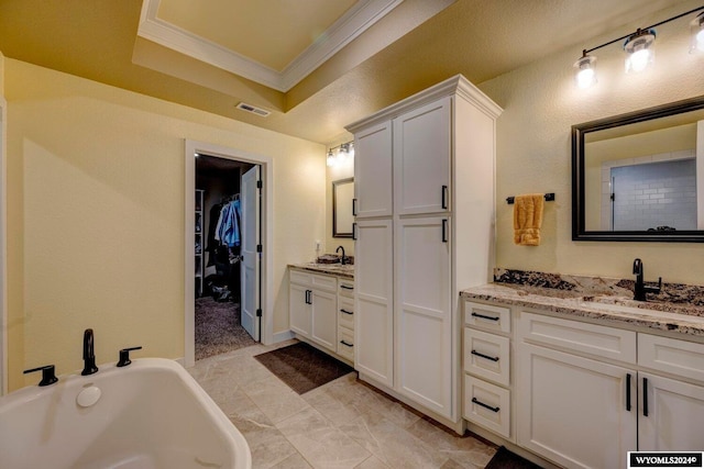 bathroom with visible vents, two vanities, ornamental molding, a sink, and a raised ceiling