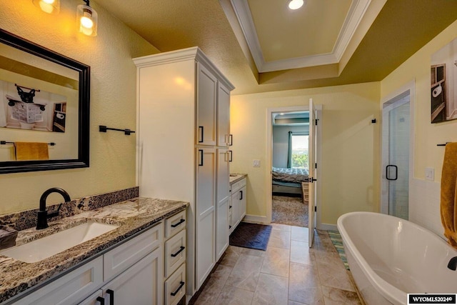 full bathroom featuring ornamental molding, ensuite bathroom, a tray ceiling, a soaking tub, and vanity