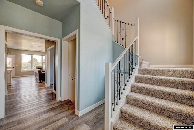 stairs featuring baseboards and wood finished floors