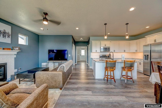 kitchen featuring open floor plan, white cabinets, and appliances with stainless steel finishes