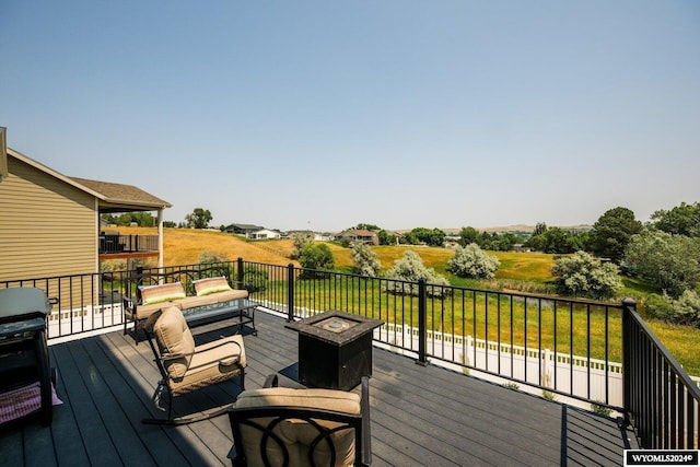 wooden terrace featuring a grill and a fire pit