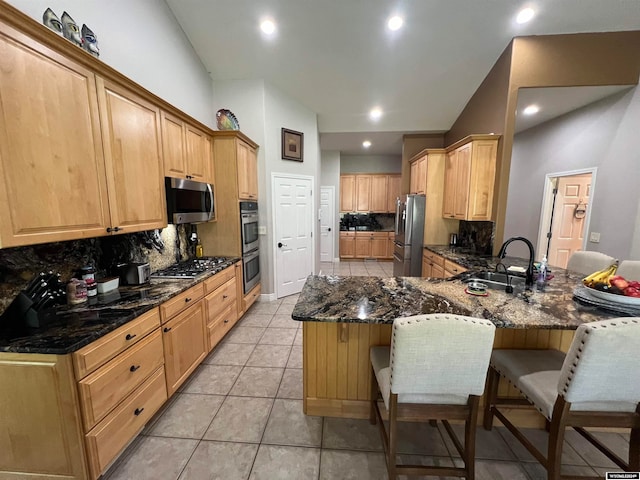 kitchen featuring appliances with stainless steel finishes, kitchen peninsula, tasteful backsplash, and light tile patterned floors