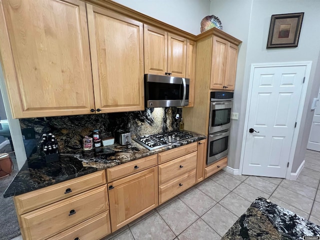 kitchen featuring light brown cabinetry, light tile patterned flooring, decorative backsplash, and stainless steel appliances