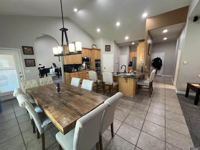 tiled dining room with an inviting chandelier and high vaulted ceiling