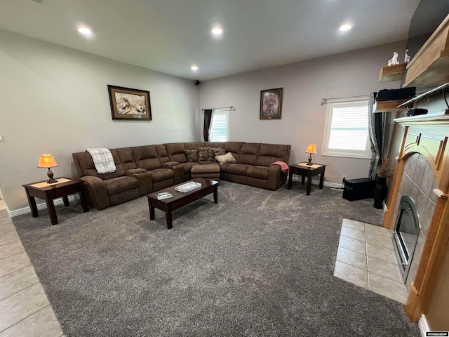 living room with a tile fireplace and light colored carpet