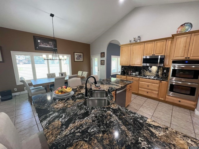 kitchen featuring appliances with stainless steel finishes, light tile patterned floors, decorative backsplash, and sink