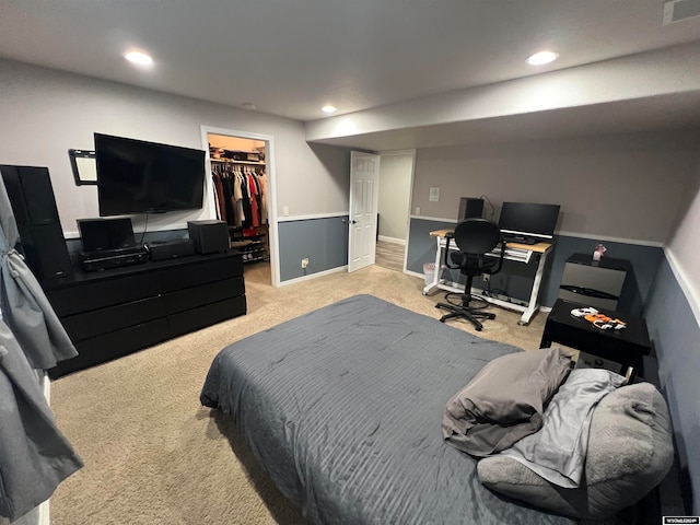 carpeted bedroom with a closet and a spacious closet