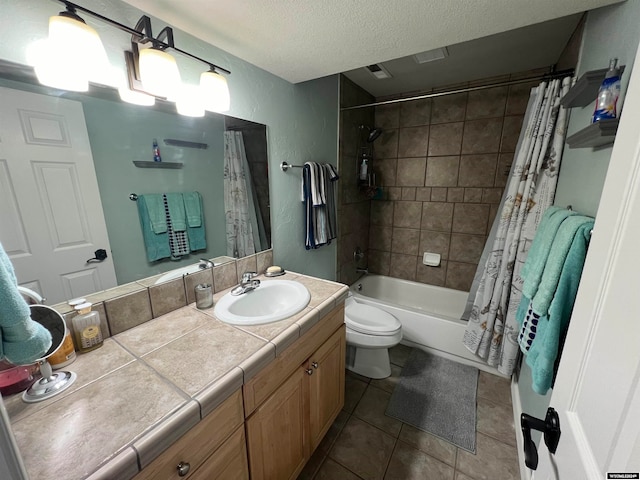 full bathroom featuring shower / tub combo with curtain, vanity, toilet, a textured ceiling, and tile patterned flooring