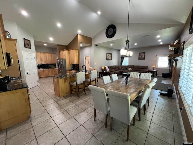 dining room with sink, light tile patterned floors, and high vaulted ceiling