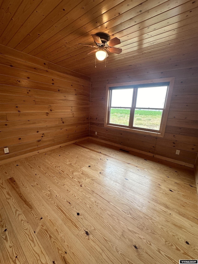 bonus room with wooden walls, wood ceiling, light wood-style flooring, and a ceiling fan