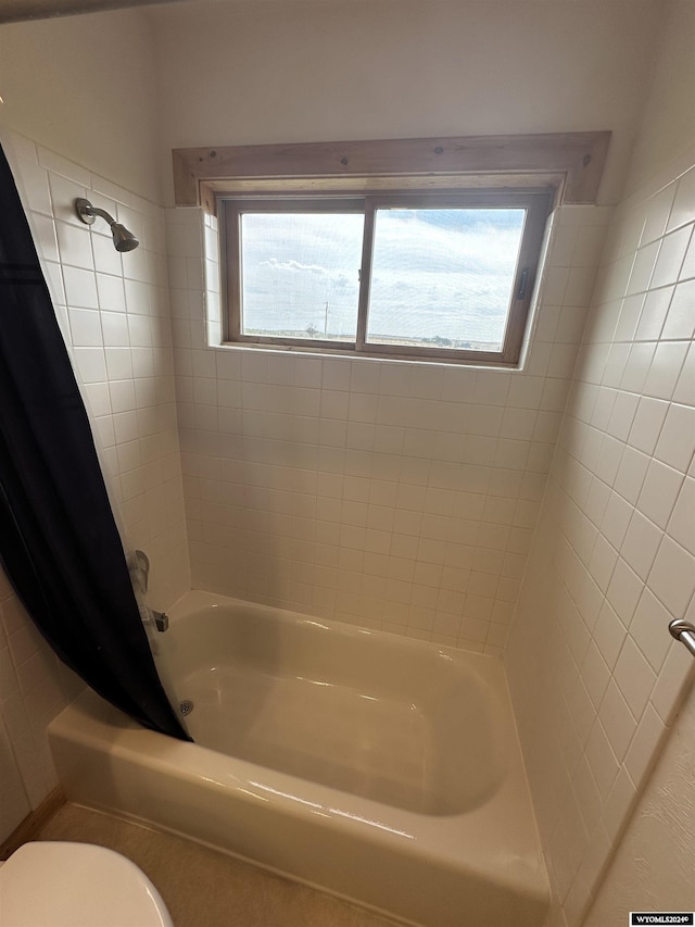 bathroom with shower / tub combo, plenty of natural light, and toilet