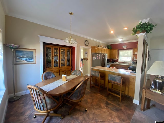 tiled dining area with a notable chandelier, crown molding, and sink