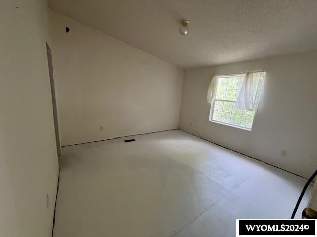 unfurnished room featuring concrete floors and a textured ceiling