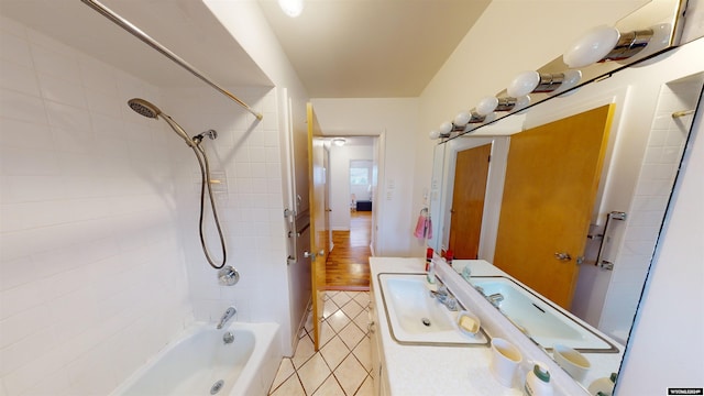 bathroom with vanity, wood-type flooring, and tiled shower / bath