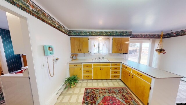 kitchen with washer / clothes dryer, sink, kitchen peninsula, and light tile patterned floors