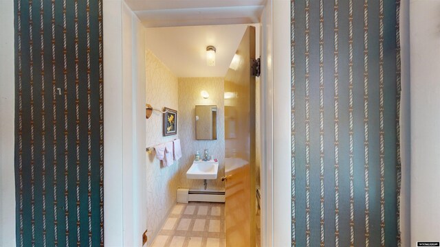 hallway featuring light tile patterned flooring, sink, and baseboard heating