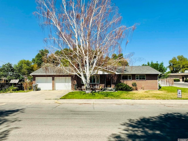 single story home featuring a garage and a front yard