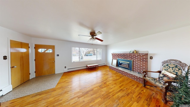 225 S 5th St, Lander, WY 82520 - unfurnished living room featuring a fireplace, a baseboard radiator, light wood finished floors, and ceiling fan
