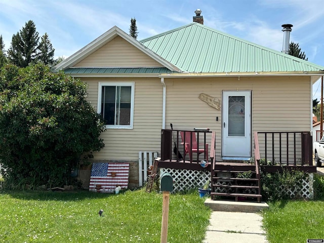 view of front of property featuring a front lawn and a wooden deck