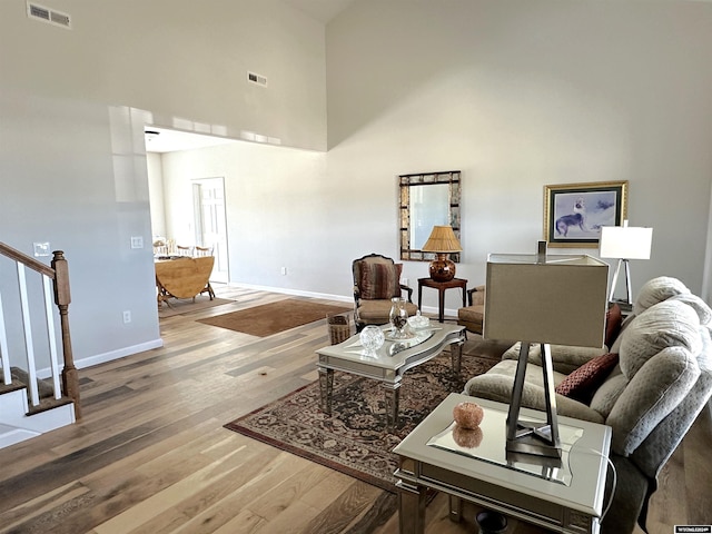 living room featuring a high ceiling and wood-type flooring