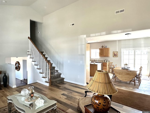 living room with high vaulted ceiling and hardwood / wood-style floors