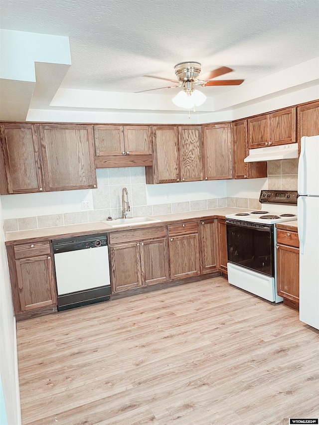 kitchen featuring ceiling fan, sink, white appliances, decorative backsplash, and light wood-type flooring