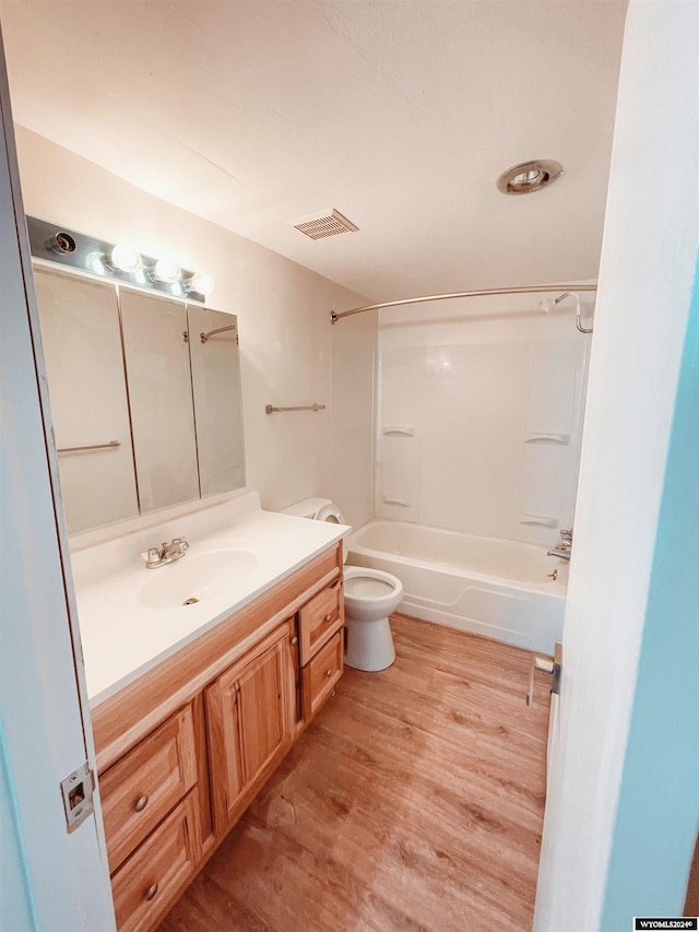 full bathroom with wood-type flooring, vanity, toilet, and  shower combination