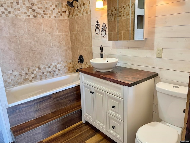 full bathroom with tiled shower / bath, vanity, toilet, and hardwood / wood-style flooring