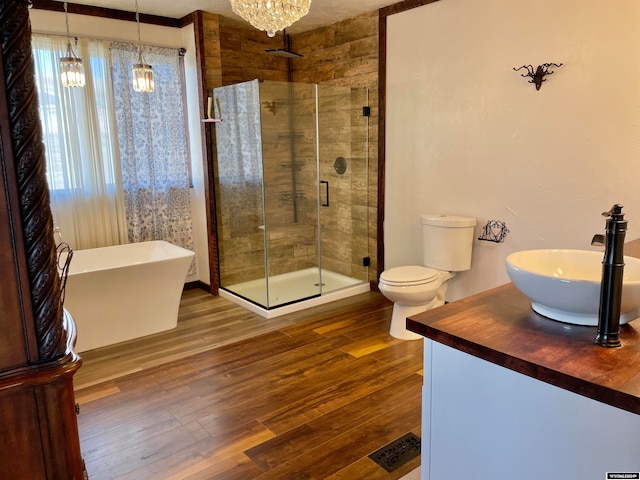 bathroom featuring toilet, a notable chandelier, ornamental molding, a shower with door, and vanity