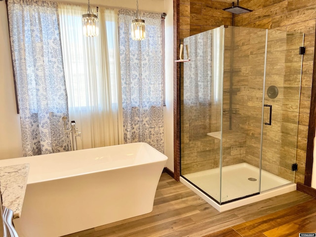 bathroom featuring shower with separate bathtub and hardwood / wood-style floors