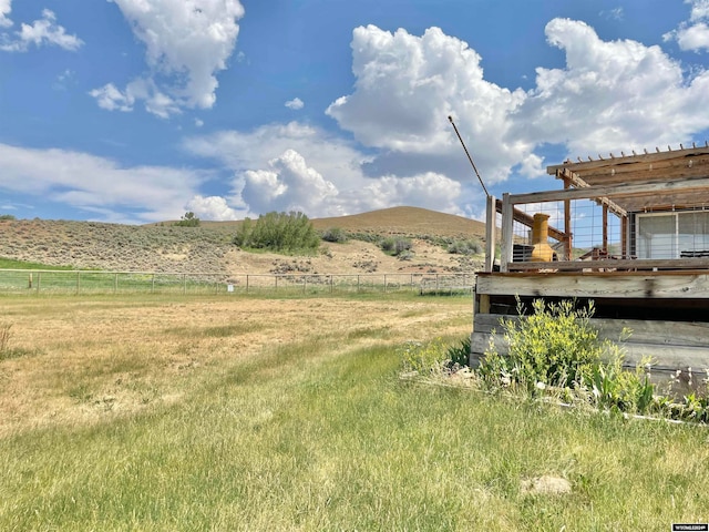 view of yard with a rural view, a pergola, and a deck with mountain view