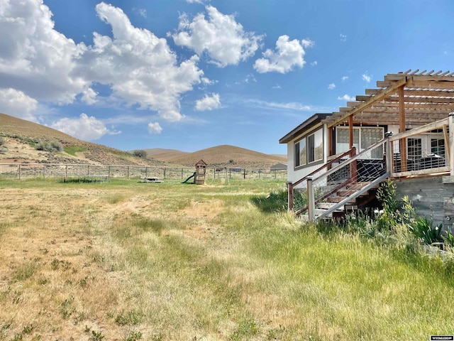 view of yard featuring a rural view, a mountain view, and a pergola