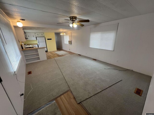 309 S Cherry, Pavillion, WY 82523 - unfurnished living room with a wealth of natural light, light hardwood / wood-style flooring, and ceiling fan with notable chandelier
