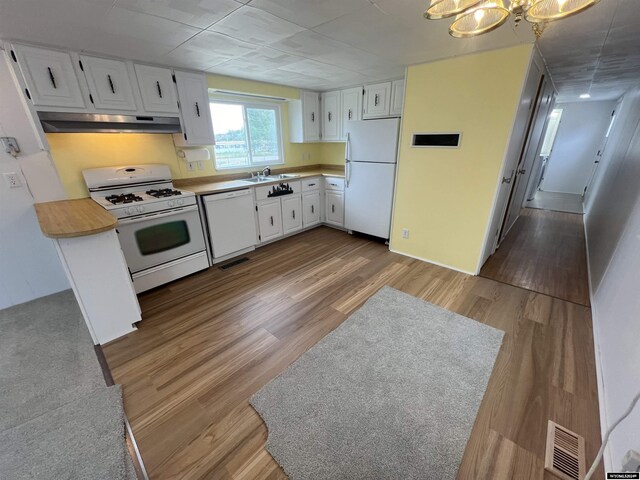 309 S Cherry, Pavillion, WY 82523 - kitchen featuring sink, white appliances, white cabinetry, a chandelier, and light wood-type flooring