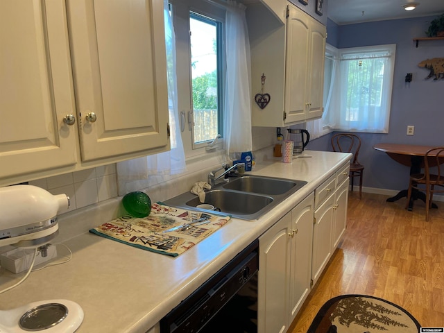 kitchen featuring sink, decorative backsplash, a healthy amount of sunlight, and light hardwood / wood-style floors