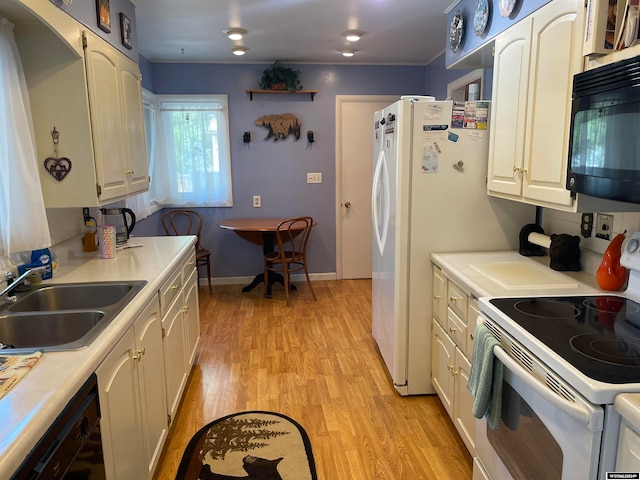 kitchen with black appliances, light hardwood / wood-style flooring, sink, and white cabinets