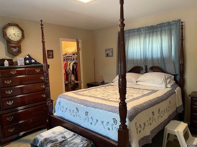 bedroom with a spacious closet, light carpet, and a closet