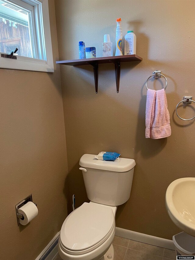 bathroom featuring sink, toilet, and tile patterned flooring