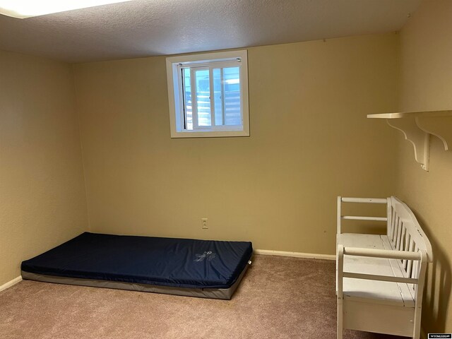 unfurnished bedroom featuring a textured ceiling and carpet