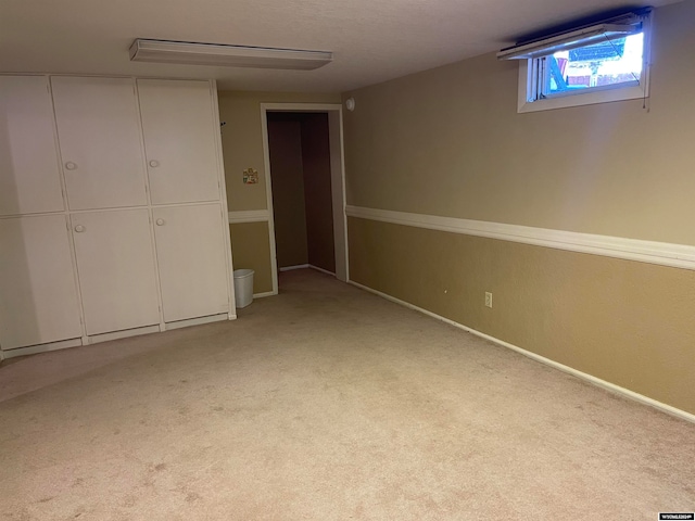 basement featuring light carpet