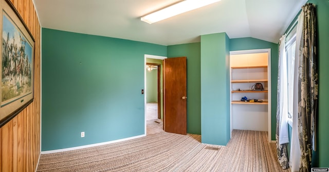 unfurnished bedroom with carpet flooring, a closet, and vaulted ceiling