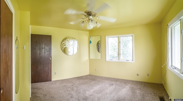 carpeted spare room featuring ceiling fan