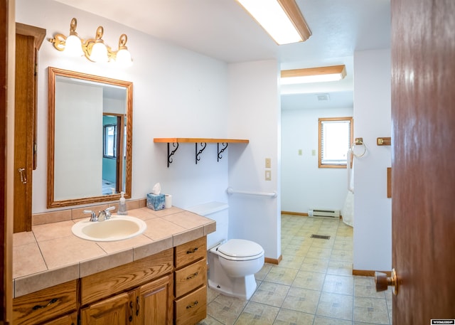 bathroom with vanity, toilet, a baseboard radiator, and tile patterned flooring