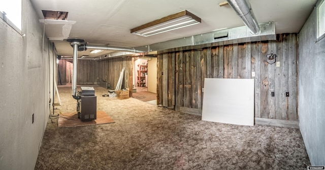 basement featuring wood walls and carpet flooring