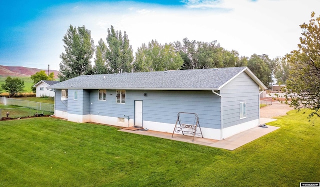 rear view of property featuring a patio and a yard