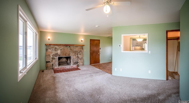 unfurnished living room with a fireplace, carpet, and ceiling fan