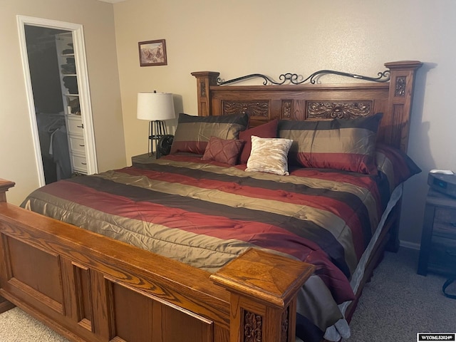 bedroom with carpet floors and a walk in closet